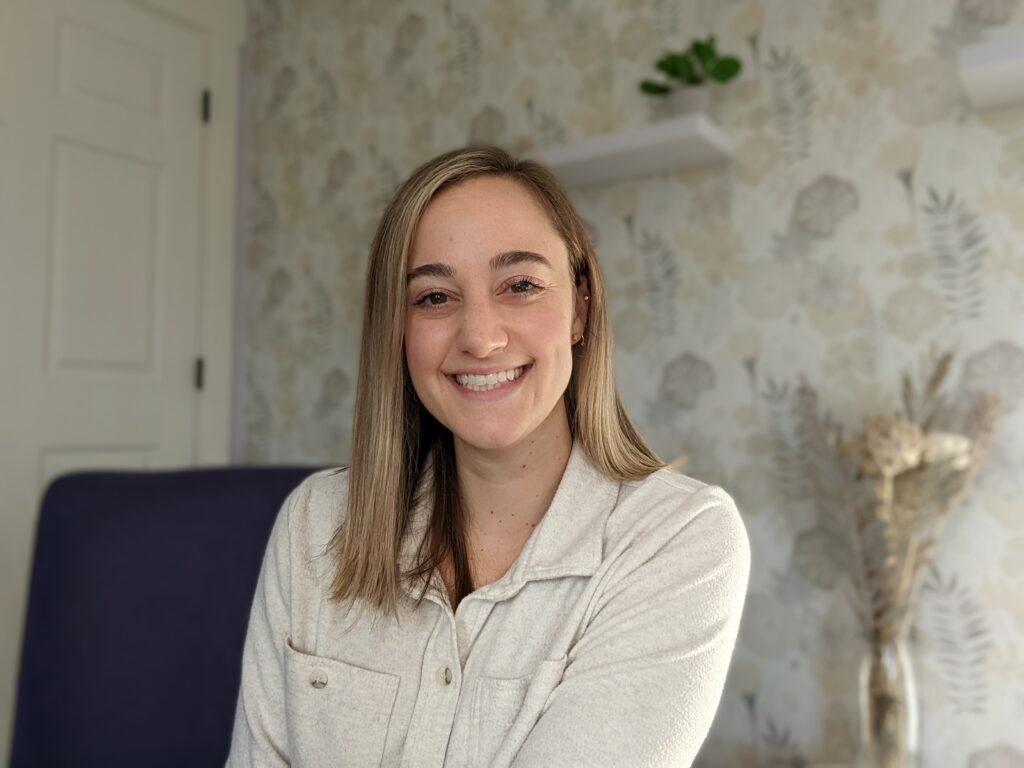 Portrait of a white woman with shoulder length light brown hair with a neutral background. Portrait is of Lexi Gross, chronic illness therapist, writer of current blog, and owner of Lexi Gross Counseling PLLC