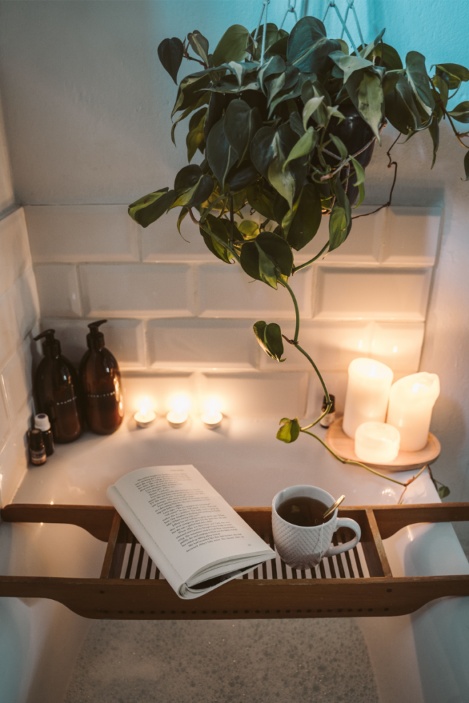 Sensory Rest Image. Image of a bathtub with candles along the edge with a plant, a book, and a cup of tea.